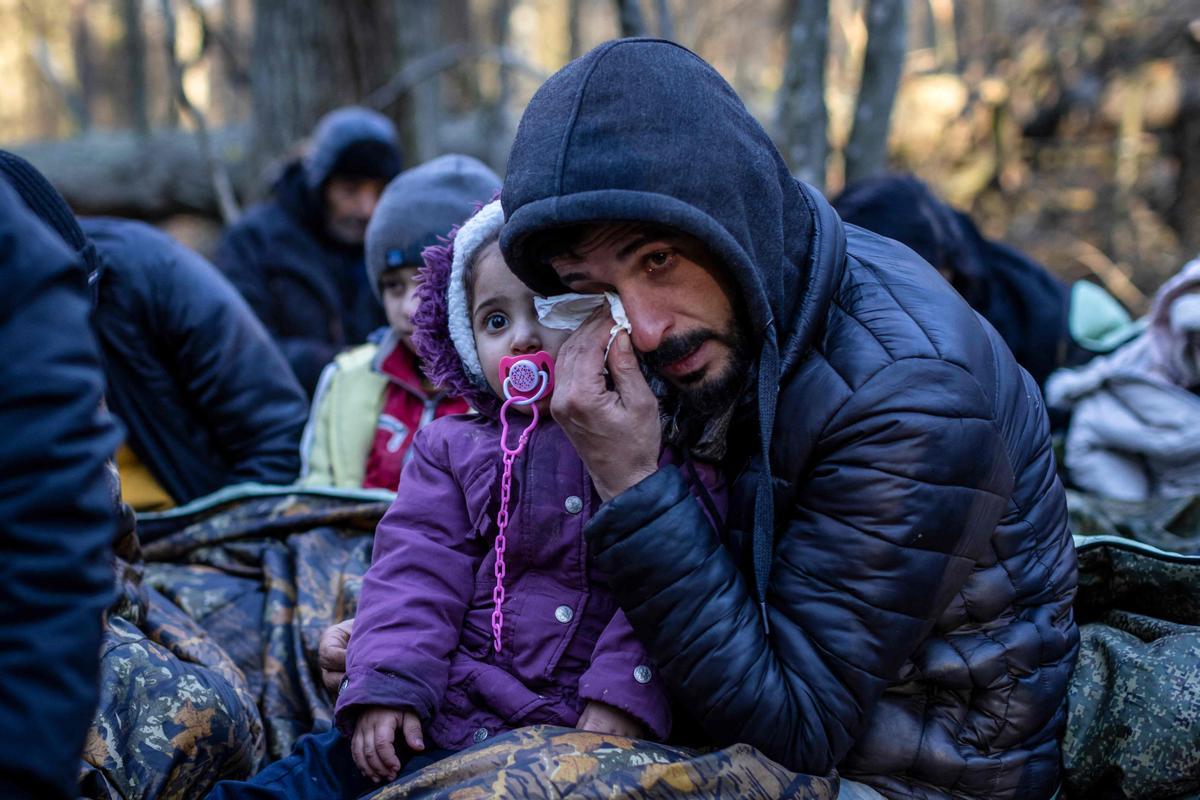 Un hombre con un niño llora, mientras espera cerca de Narewka, en la frontera.