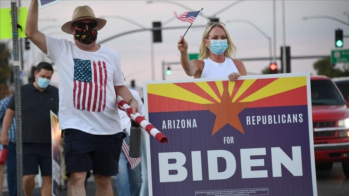 Miembros del grupo ’Republicanos de Arizona que creen en tratar a los otros con respeto’ con un cartel en apoyo a Biden, este sábado en Phoenix. Miembros del grupo ’Republicanos de Arizona que creen en tratar a los otros con respeto’ con un cartel en apoyo a Biden, este sábado en Phoenix.