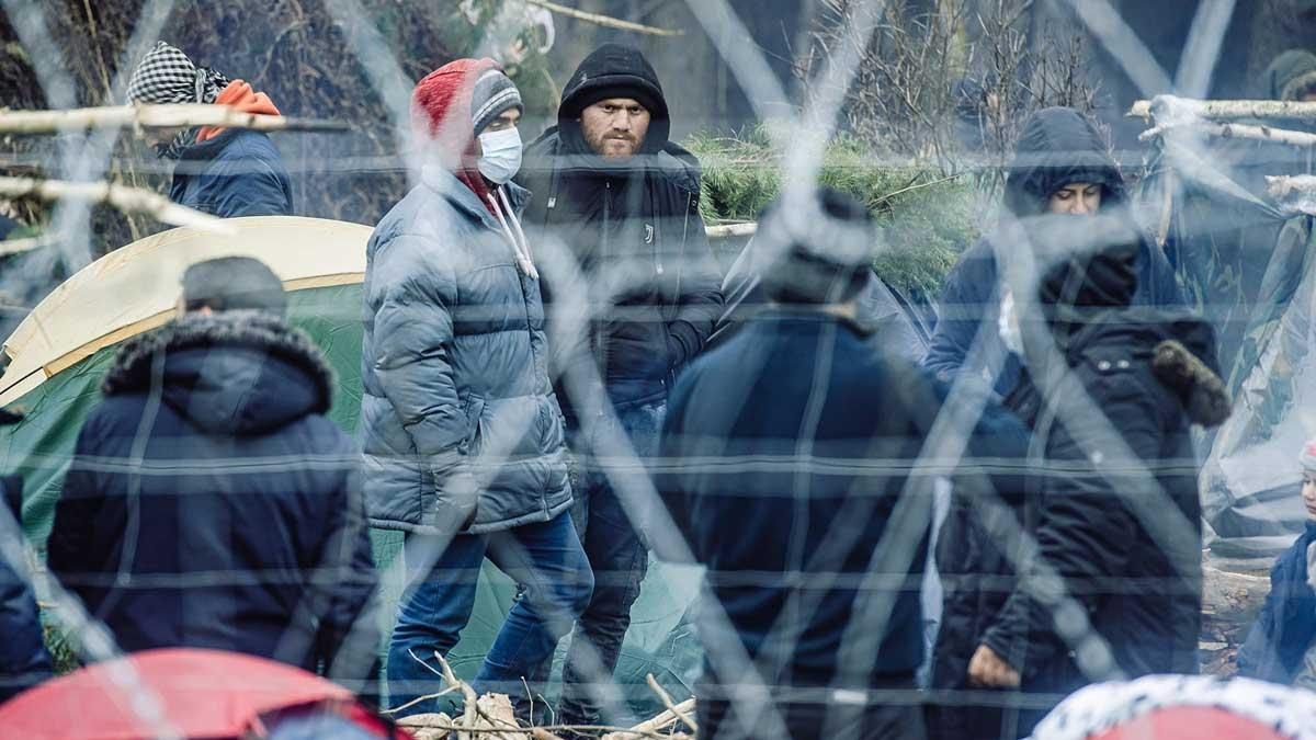 Migrantes tras la valla fronteriza en Bielorrusia, cerca del paso fronterizo de Kuznica, entre Polonia y Bielorrusia.