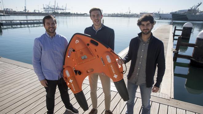 Los fundadores de la empresa Proteus posan con el prototipo de su dron marino de salvamento. 