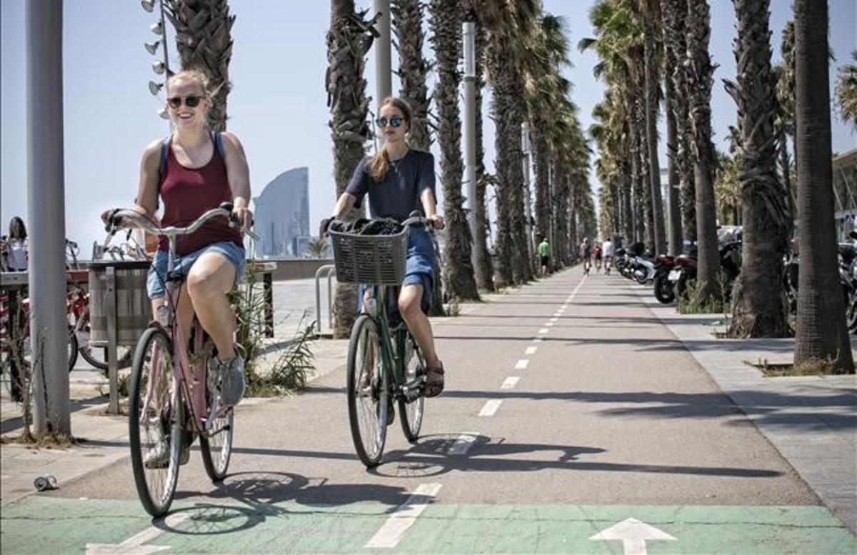 Unos ciclistas circulan por el carril bici ubicado frente al Hospital del Mar, en la Vila Olímpica de Barcelona.
