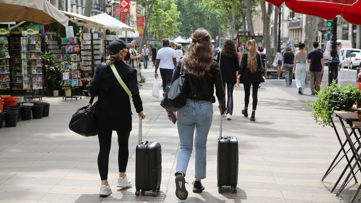 Dos turistas arrastran sus maletas por la Rambla el pasado 31 de mayo, una escena casi inédita durante la pandemia. Dos turistas arrastran sus maletas por la Rambla el pasado 31 de mayo, una escena casi inédita durante la pandemia.