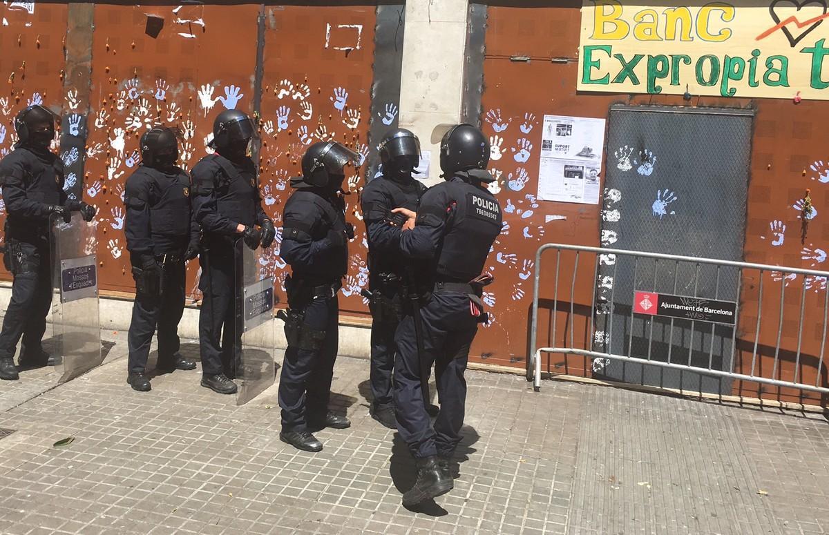 Antidisturbios de los Mossos, frente al local del ’banco expropiado’ de Gràcia, este domingo.