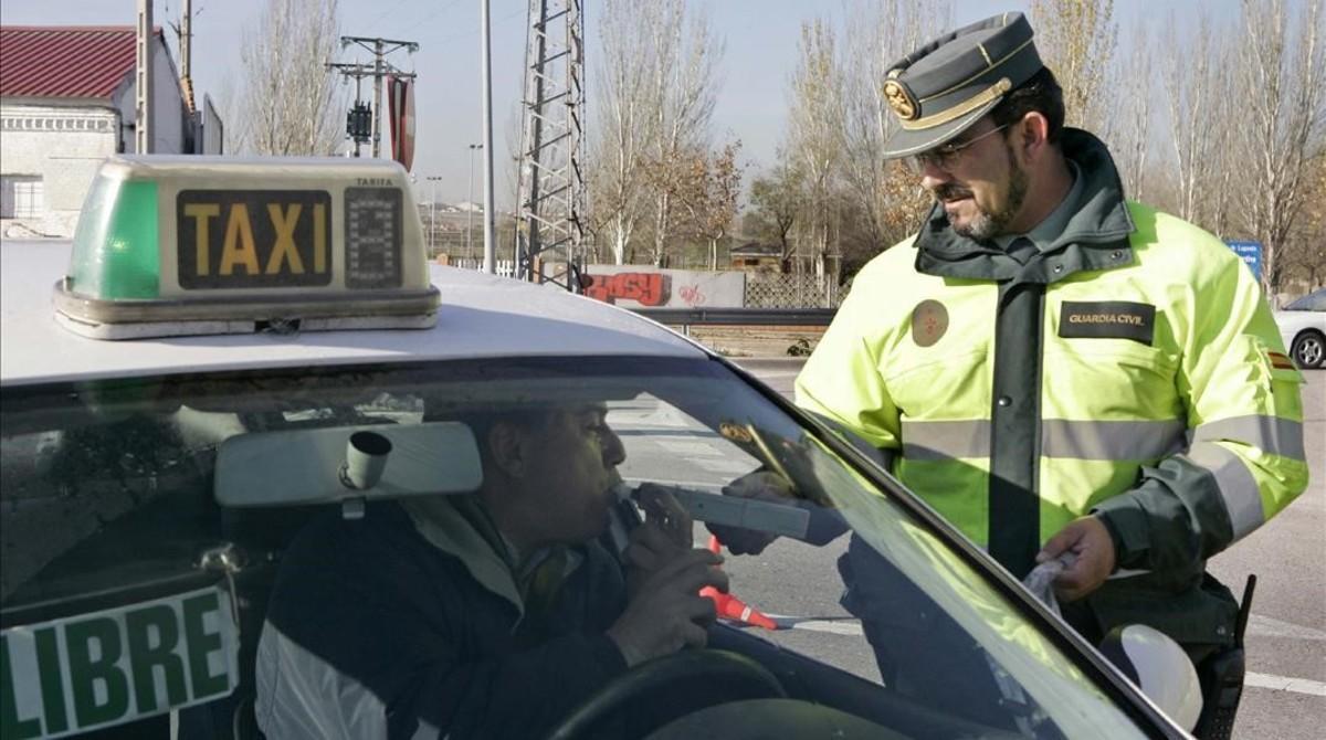 Un conductor se somete a una prueba de alcoholemia ante un agente de la Guardia Civil, en Madrid.