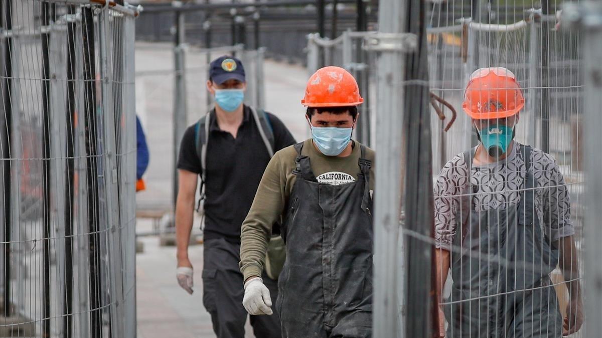 Trabajadores de la construcción se reincorporan a sus puestos tras seis semanas de vacaciones retribuidas, este martes en Moscú.