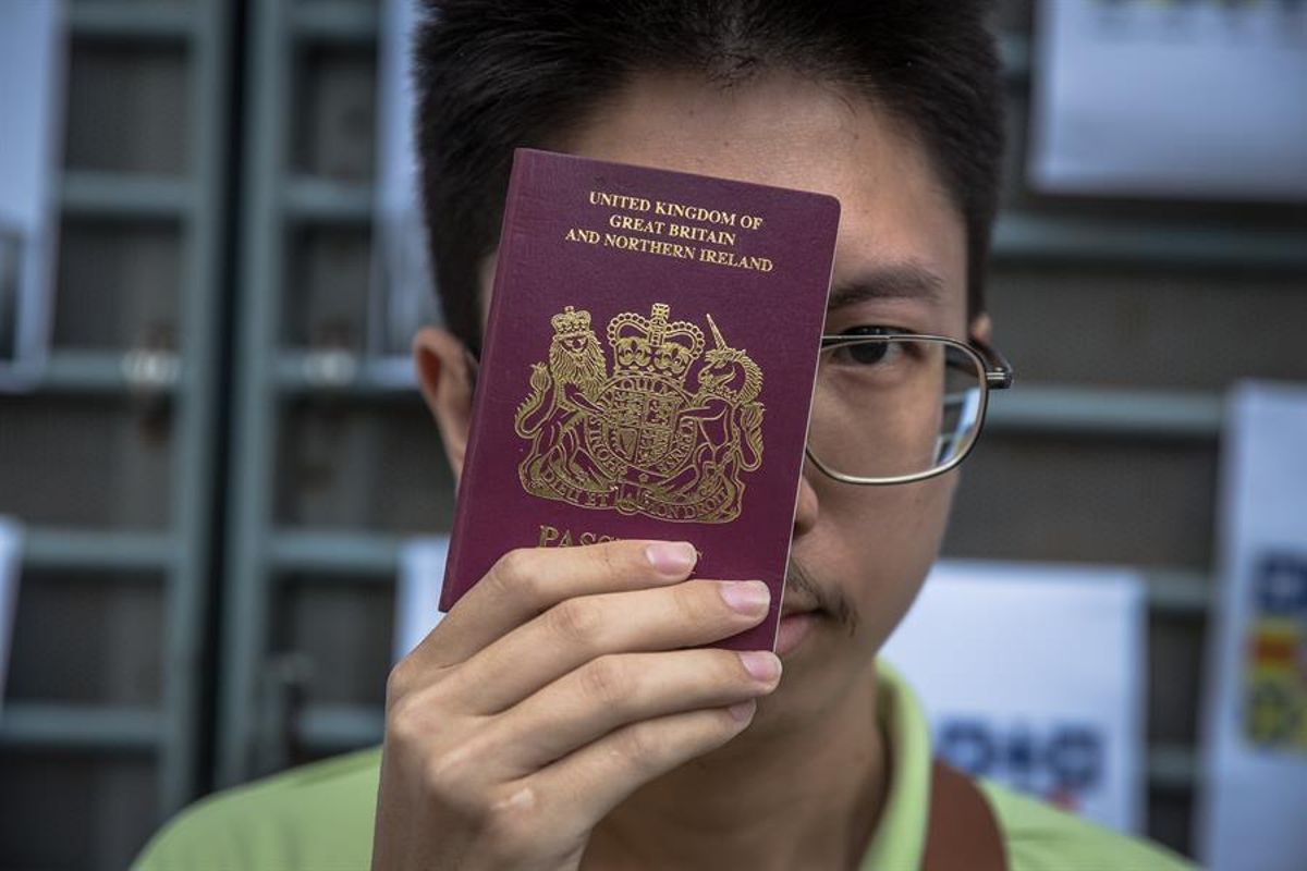 Un hongkonés posa con su pasaporte británico. Un hongkonés posa con su pasaporte británico.