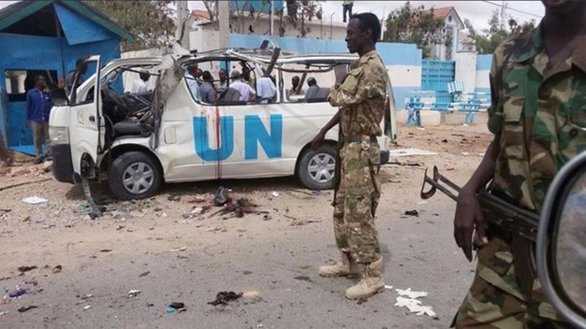 Militares vigilan la furgoneta destrozada por el ataque bomba de Al Shabaab, en Garowa, Somalia.