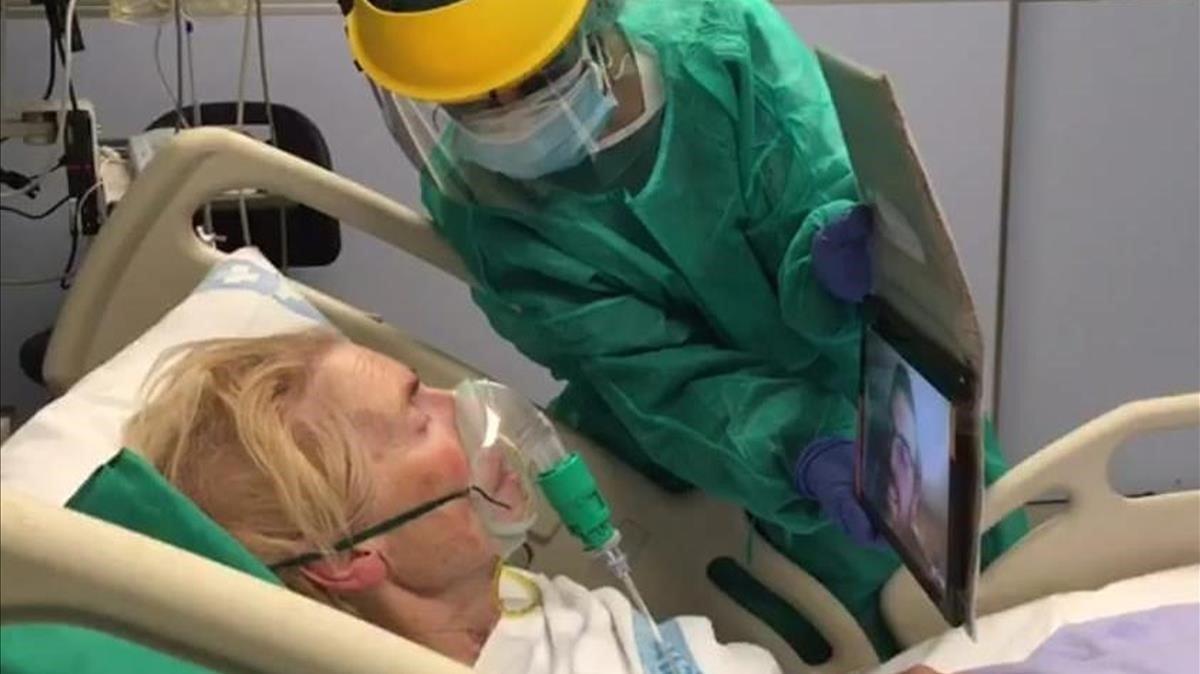 Una paciente con covid-19 ingresada en el hospital Josep Trueta de Girona hace una videollamada con un familiar