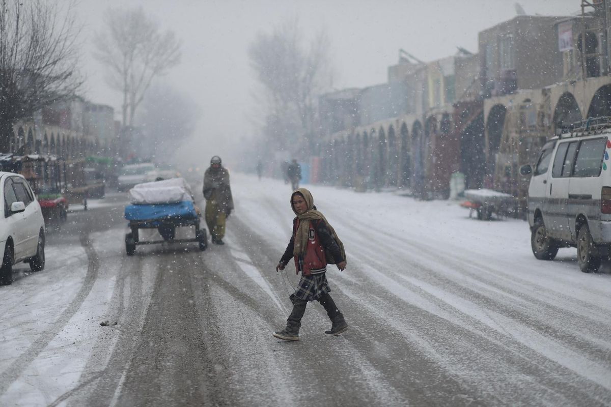 Una chica cruza una calle cubierta por la nieve en Bamiyan, Afganistán. Una chica cruza una calle cubierta por la nieve en Bamiyan, Afganistán.