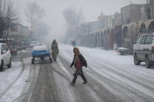 Una chica cruza una calle cubierta por la nieve en Bamiyan, Afganistán.