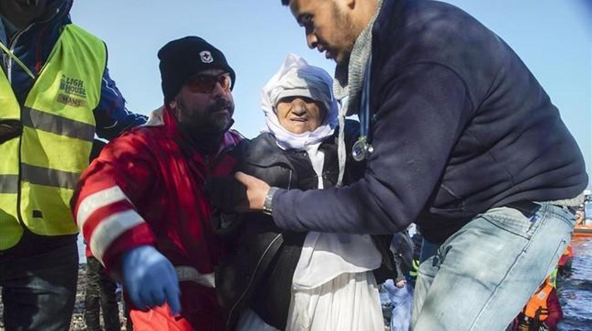 Voluntarios ayudan a una mujer anciana de Afganistán tras desembarcar con otros refugiados en Skala Sykaminias, en Lesbos, este miércoles. Voluntarios ayudan a una mujer anciana de Afganistán tras desembarcar con otros refugiados en Skala Sykaminias, en Lesbos, este miércoles.