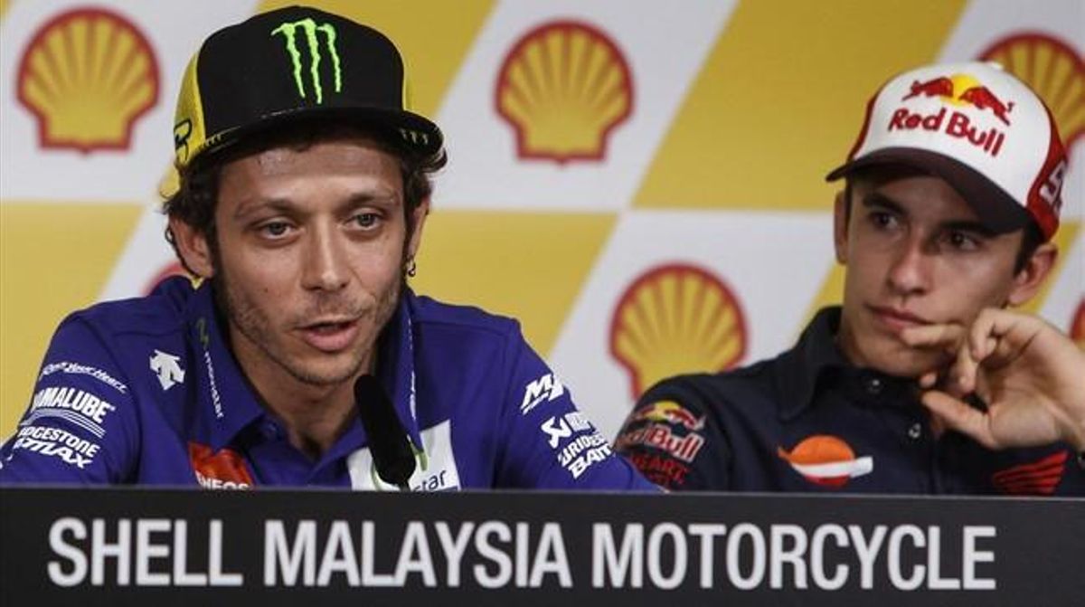 Valentino Rossi explica sus sensaciones antes del Gran Premio de Malasia, bajo la atenta mirada de Marc Márquez. Valentino Rossi explica sus sensaciones antes del Gran Premio de Malasia, bajo la atenta mirada de Marc Márquez.